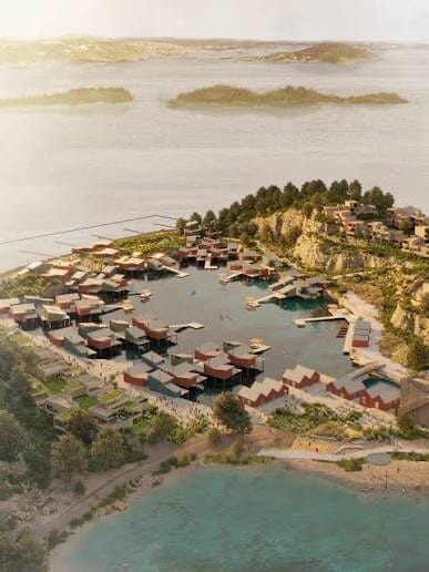 Aerial view: modern waterfront village with stilt houses in a bay, buildings on surrounding green hills.