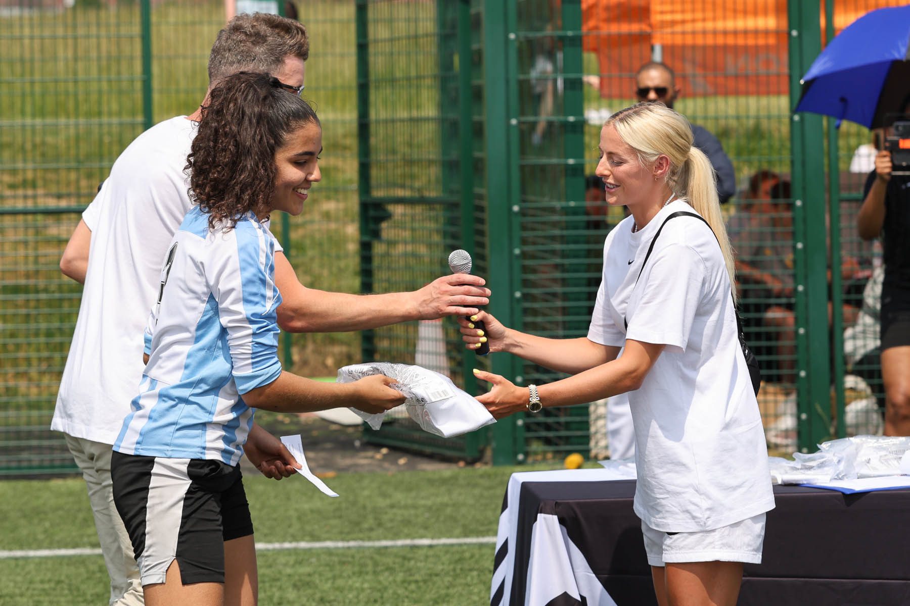Chloe Kelly handing a giveaway to a girl