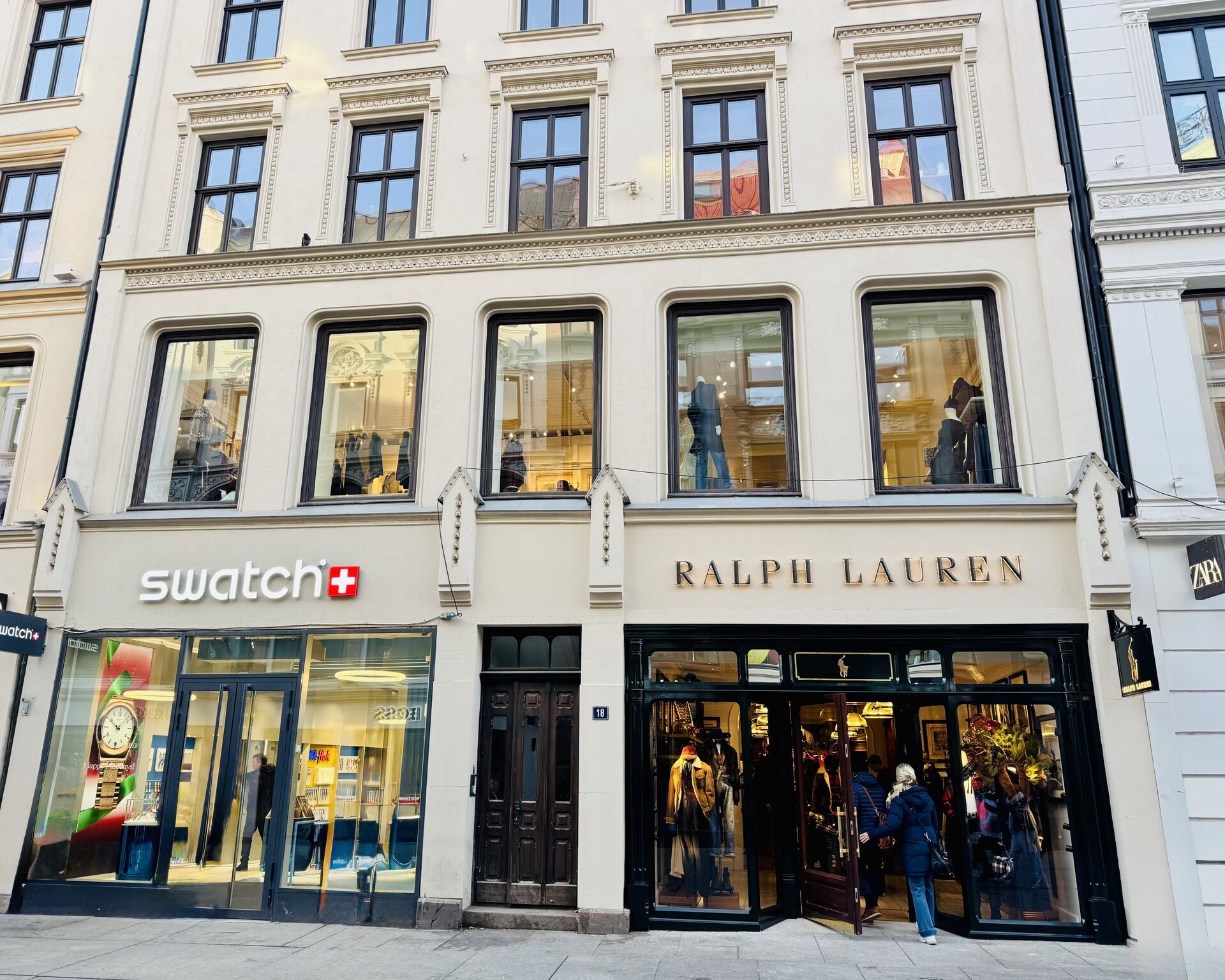Swatch and Ralph Lauren storefronts on a multi-story building.