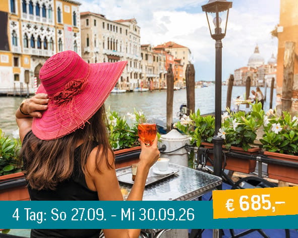 Woman in a red hat enjoying a drink at a cafe overlooking the Grand Canal in Venice.