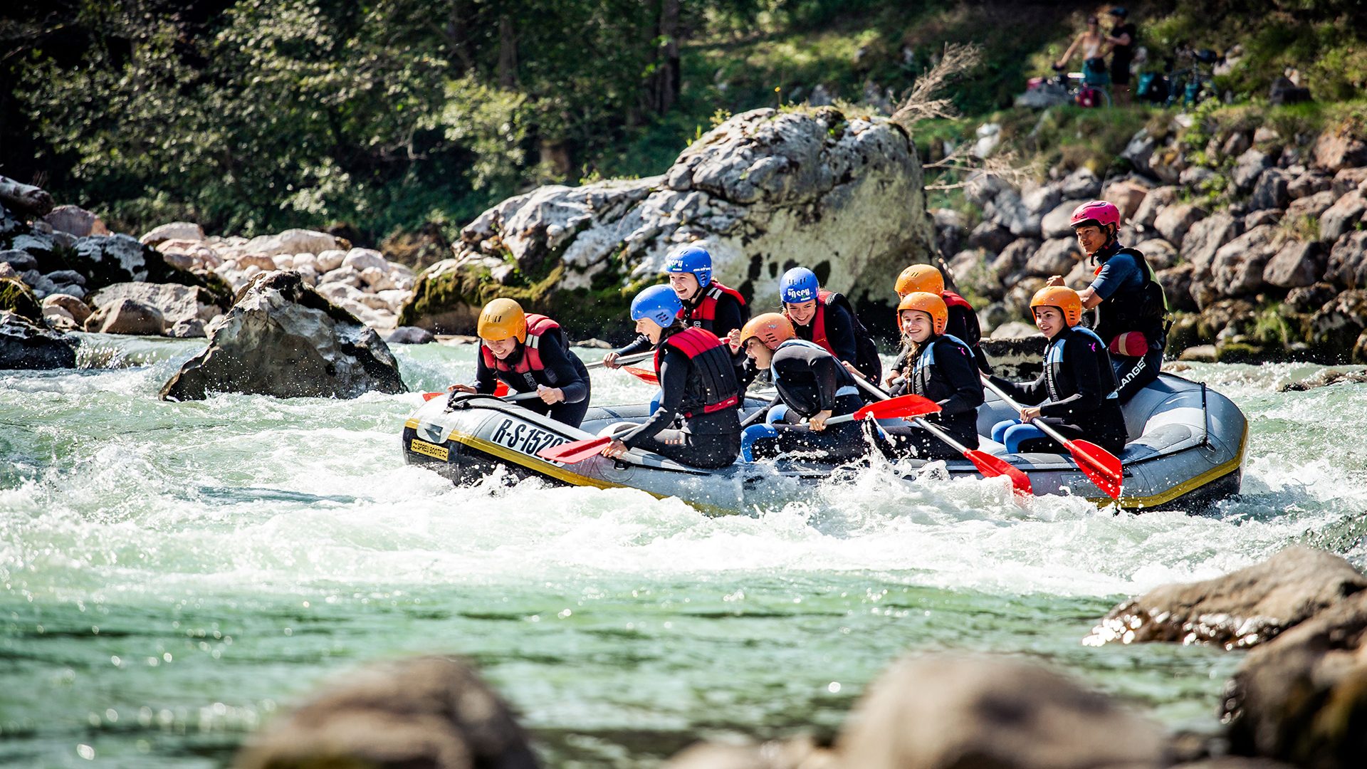 A group white-water rafting down a rocky river.