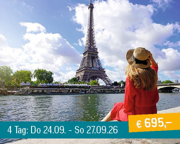 Woman in red dress and hat sitting by the Seine river, admiring the Eiffel Tower in Paris.