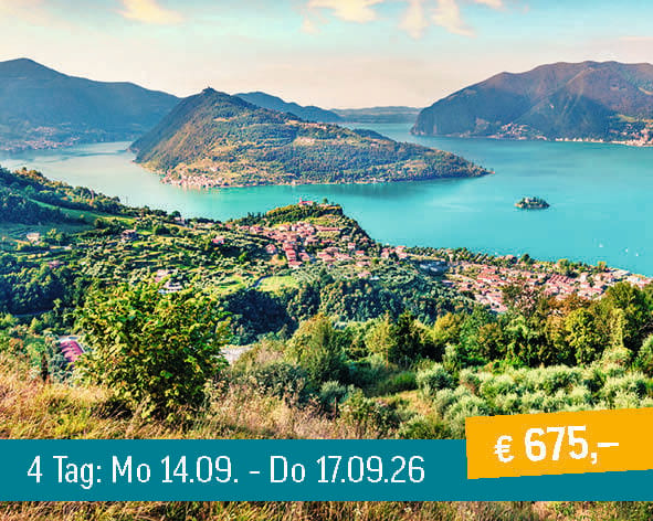A picturesque aerial view of a vibrant blue lake surrounded by lush green mountains and charming hillside towns.