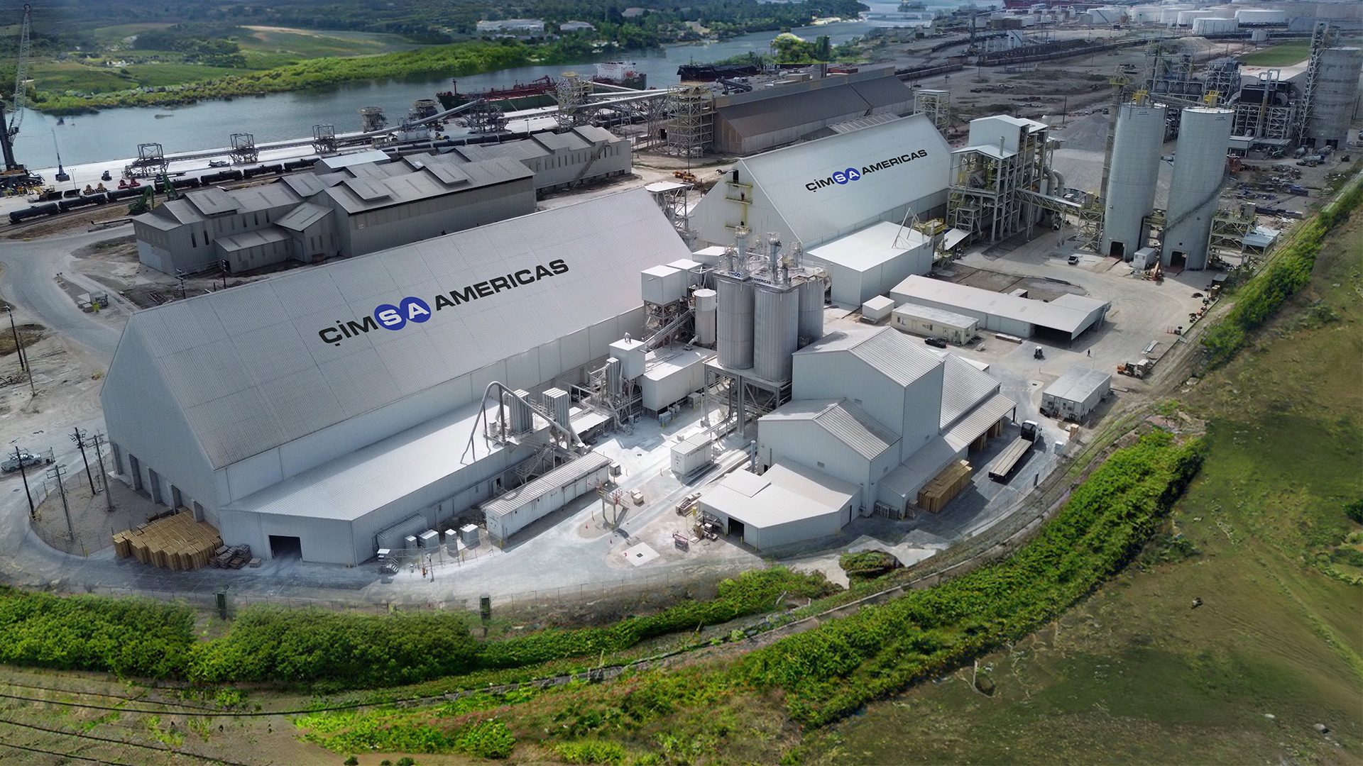 Aerial view of CIMSA AMERICAS industrial plant with silos and port facilities.