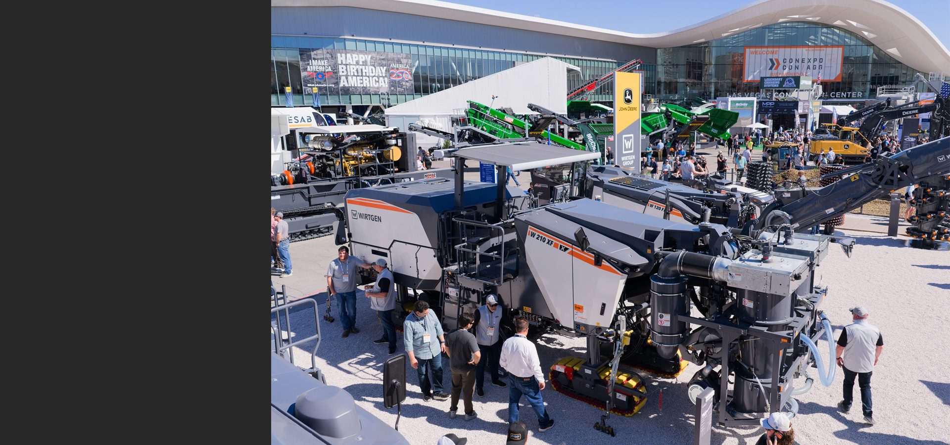 Attendees gather around WIRTGEN road milling machines at the CONEXPO construction trade show.