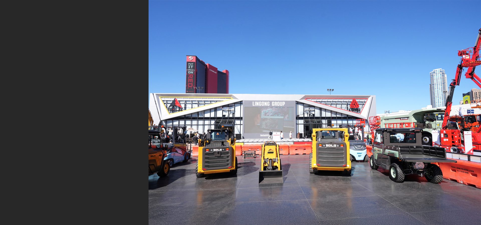 Lingong Group exhibit featuring construction equipment, skid steers, and utility vehicles under a blue sky.