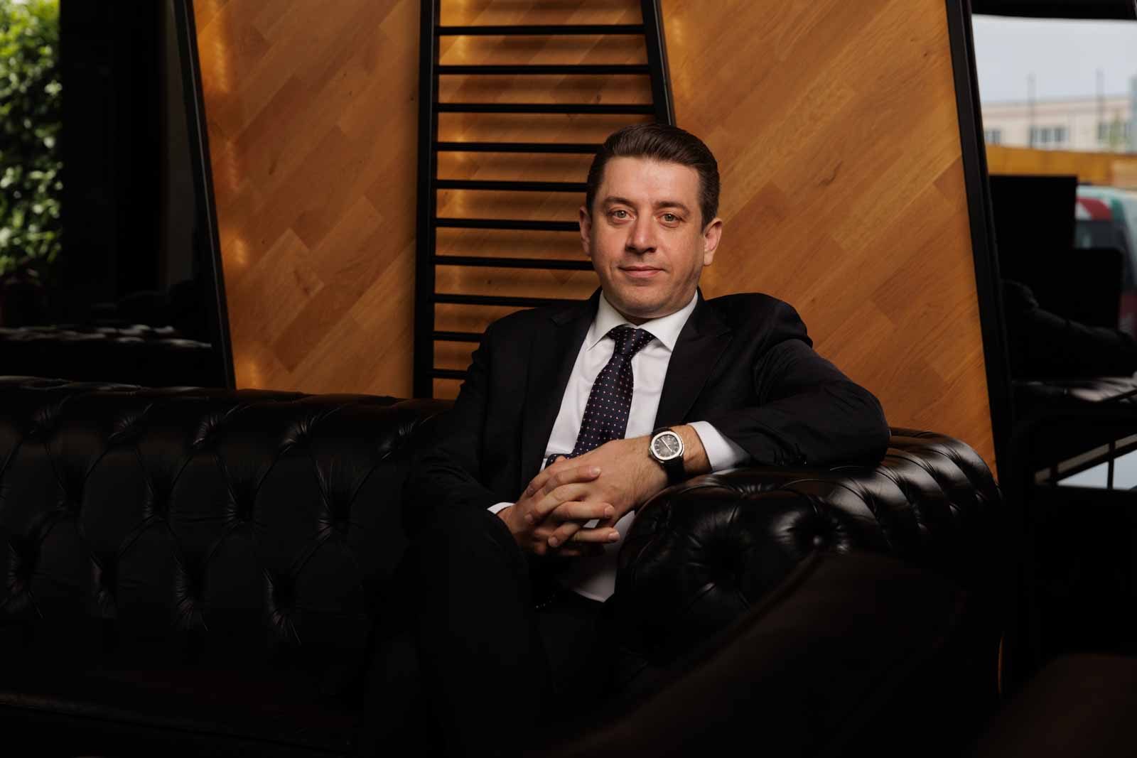 Formal wear, White-collar worker, Furniture, Sitting, Suit, Blazer, Couch, Necktie, Coat, Comfort