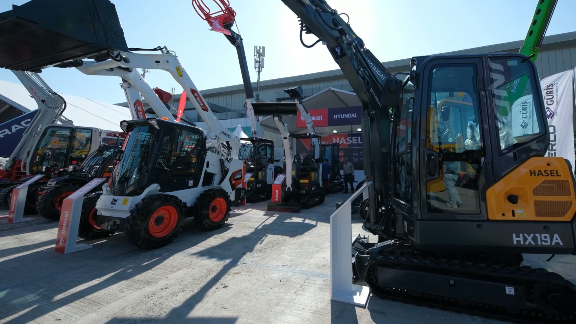 Outdoor display of Bobcat and Hyundai construction vehicles, including excavators and loaders.