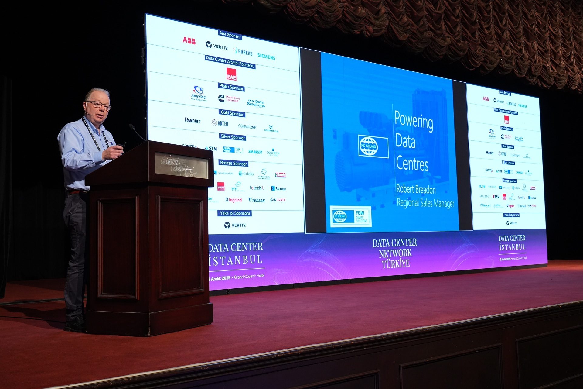 Man speaks at podium, screen shows "Powering Data Centres" for Data Center Istanbul.