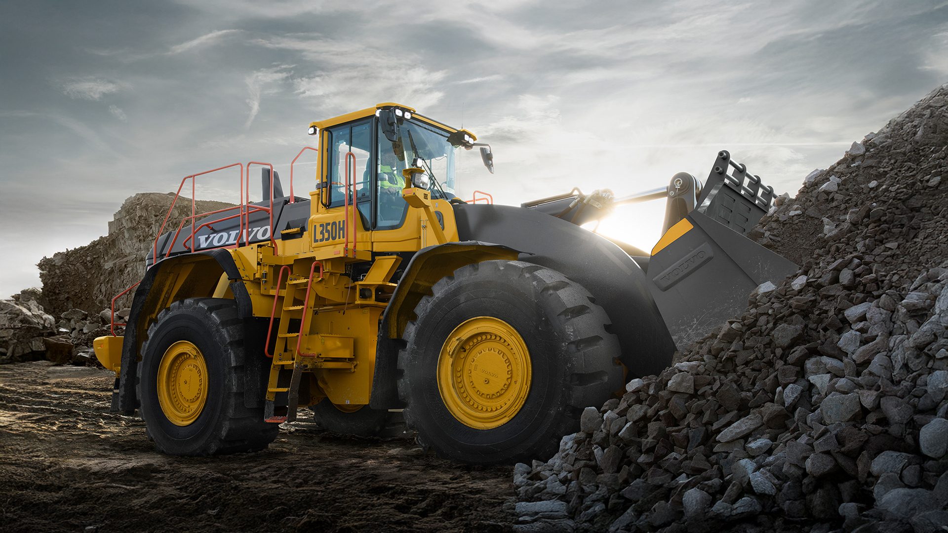 Yellow Volvo L350H loader pushing rocks at a quarry.