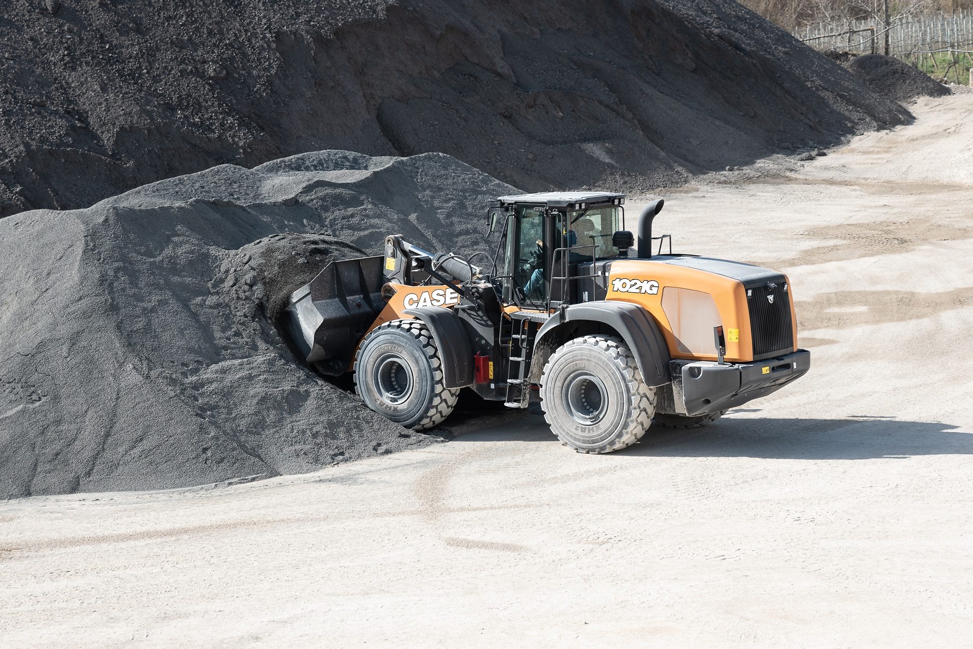 CASE 1021G loader scoops gravel from a pile in a quarry.