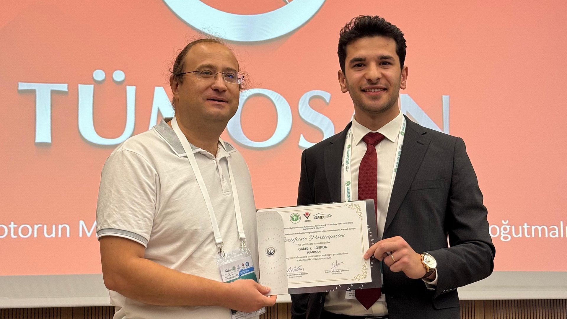 Two men smiling, holding a "Certificate of Participation" from ISASTECH 2025.