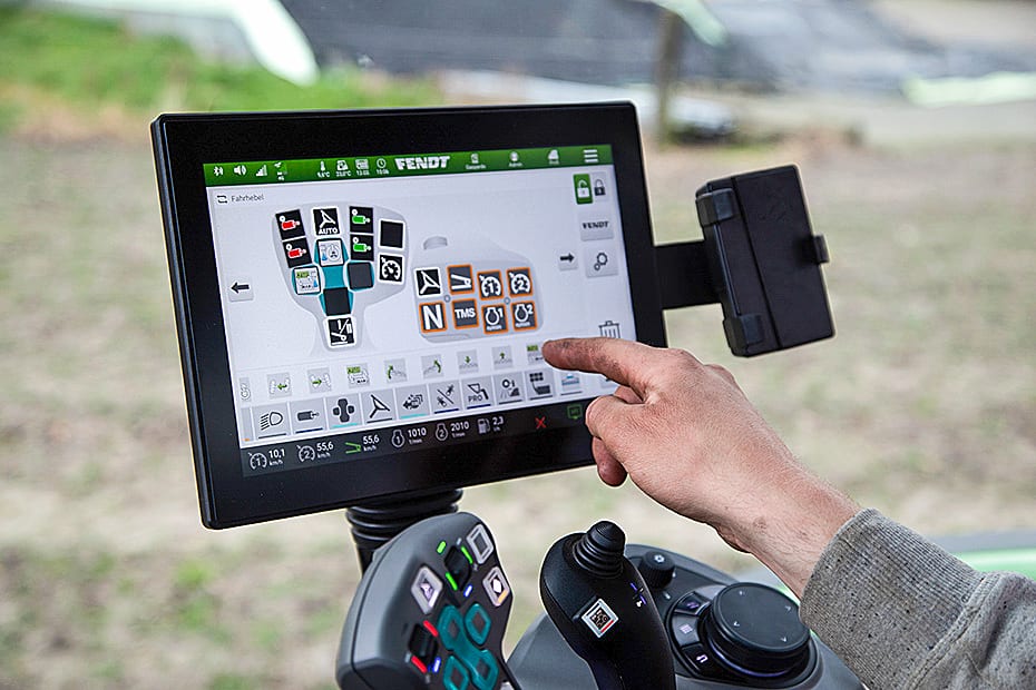 Hand touches Fendt tractor touchscreen displaying vehicle controls and settings.