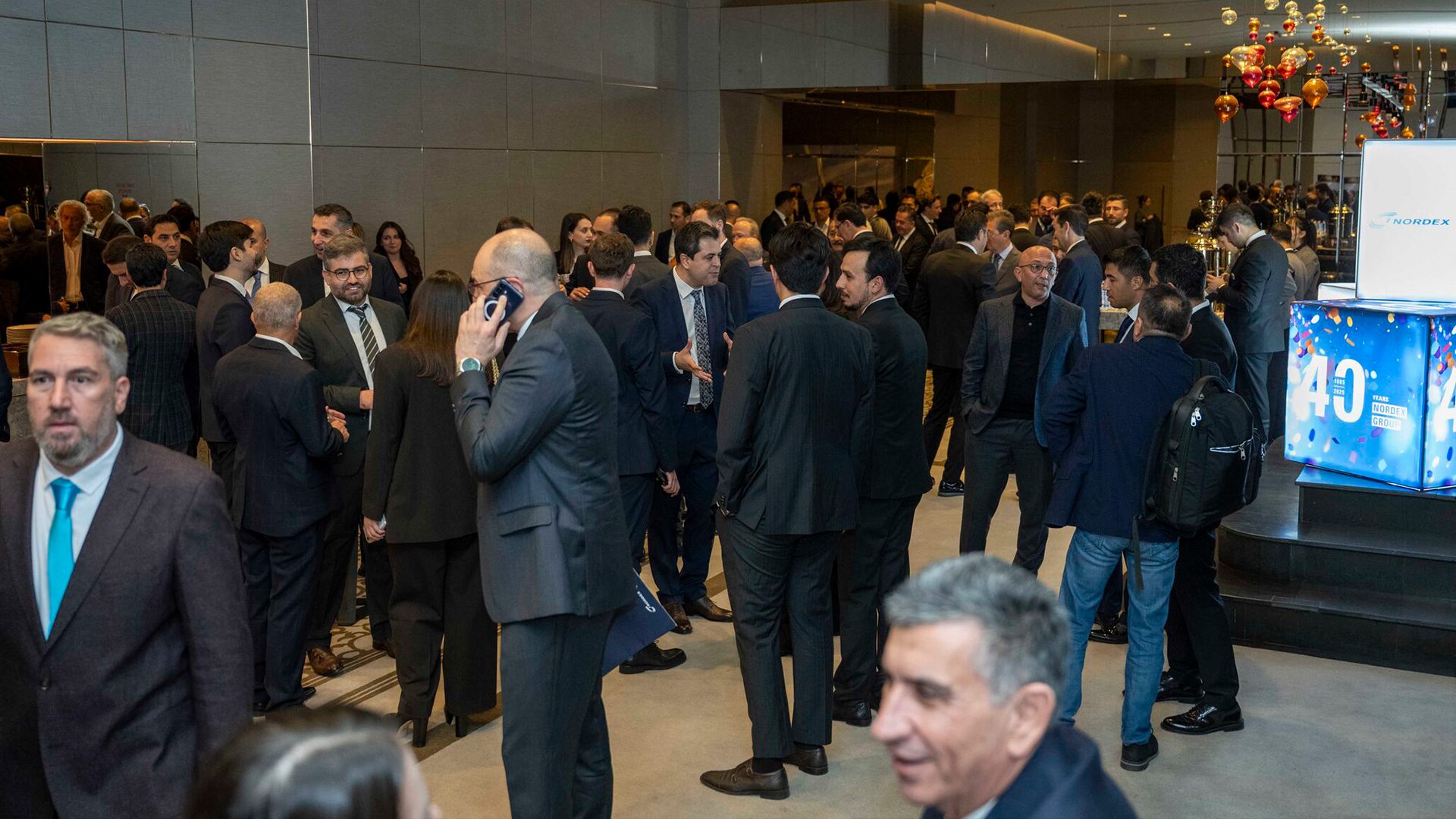 Crowd of professionals in suits at a Nordex Group 40th anniversary event.