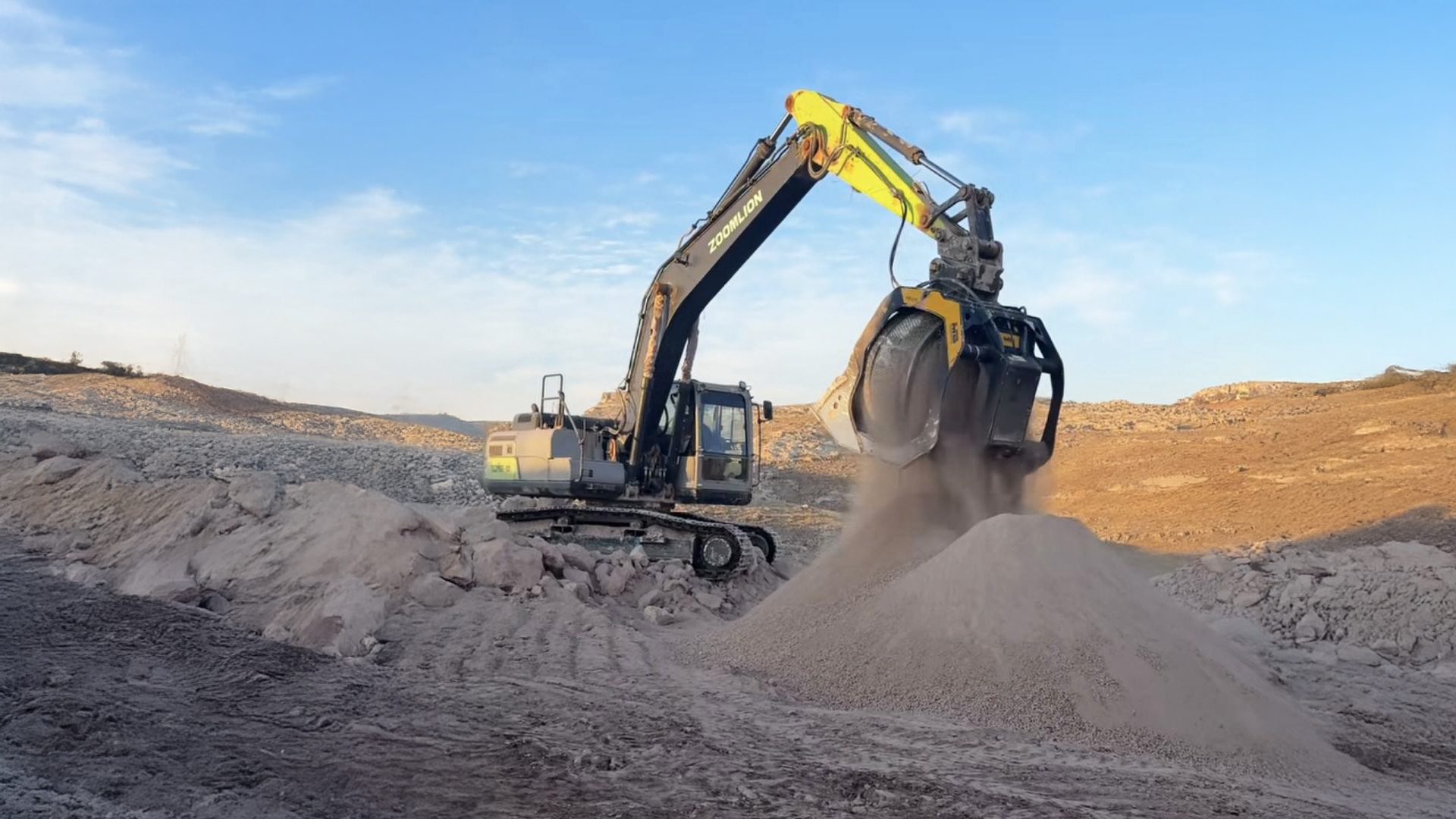 A Zoomlion excavator drops sand, creating dust, at a sunny construction or quarry site.