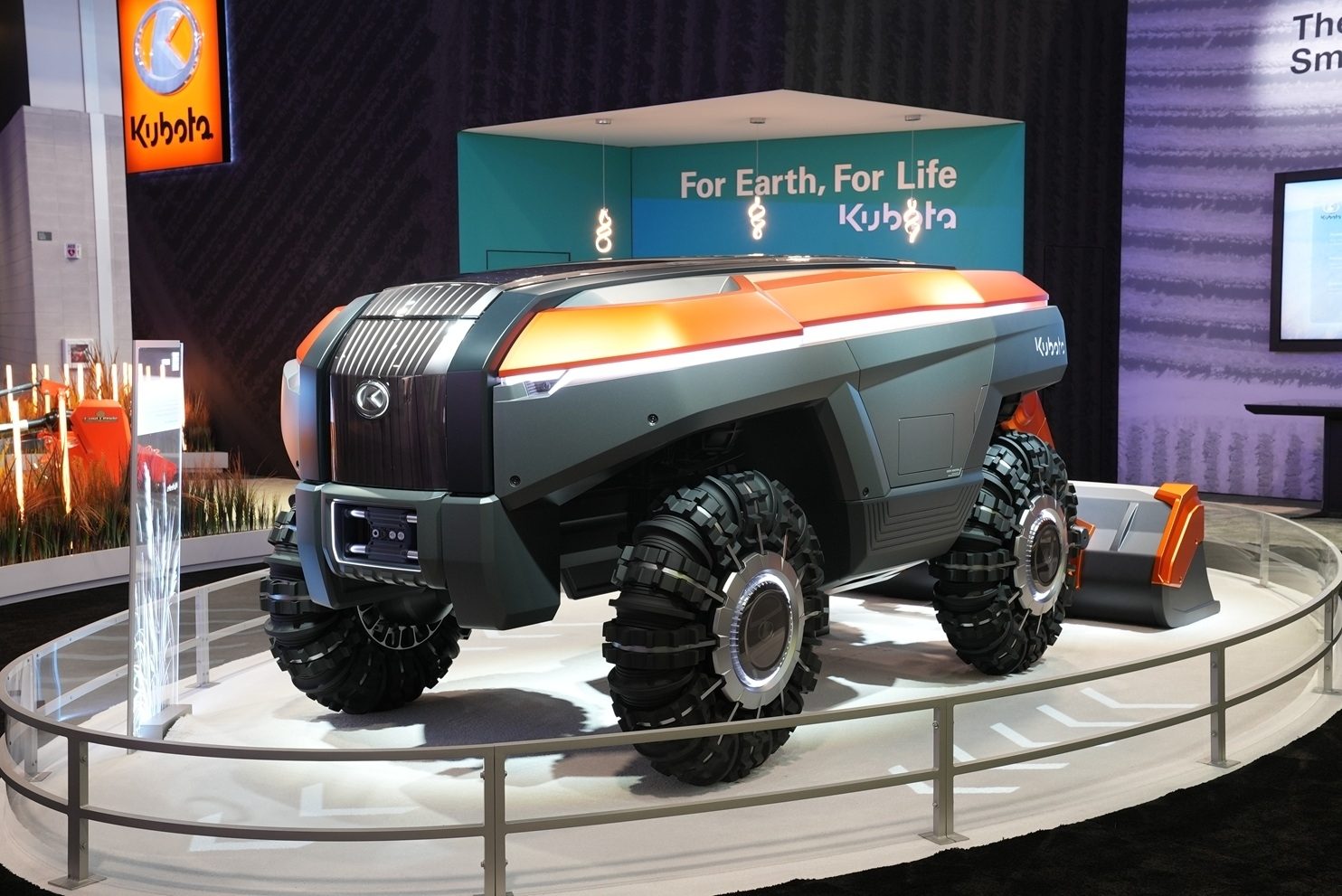 Kubota's futuristic concept vehicle on display with "For Earth, For Life" banner.
