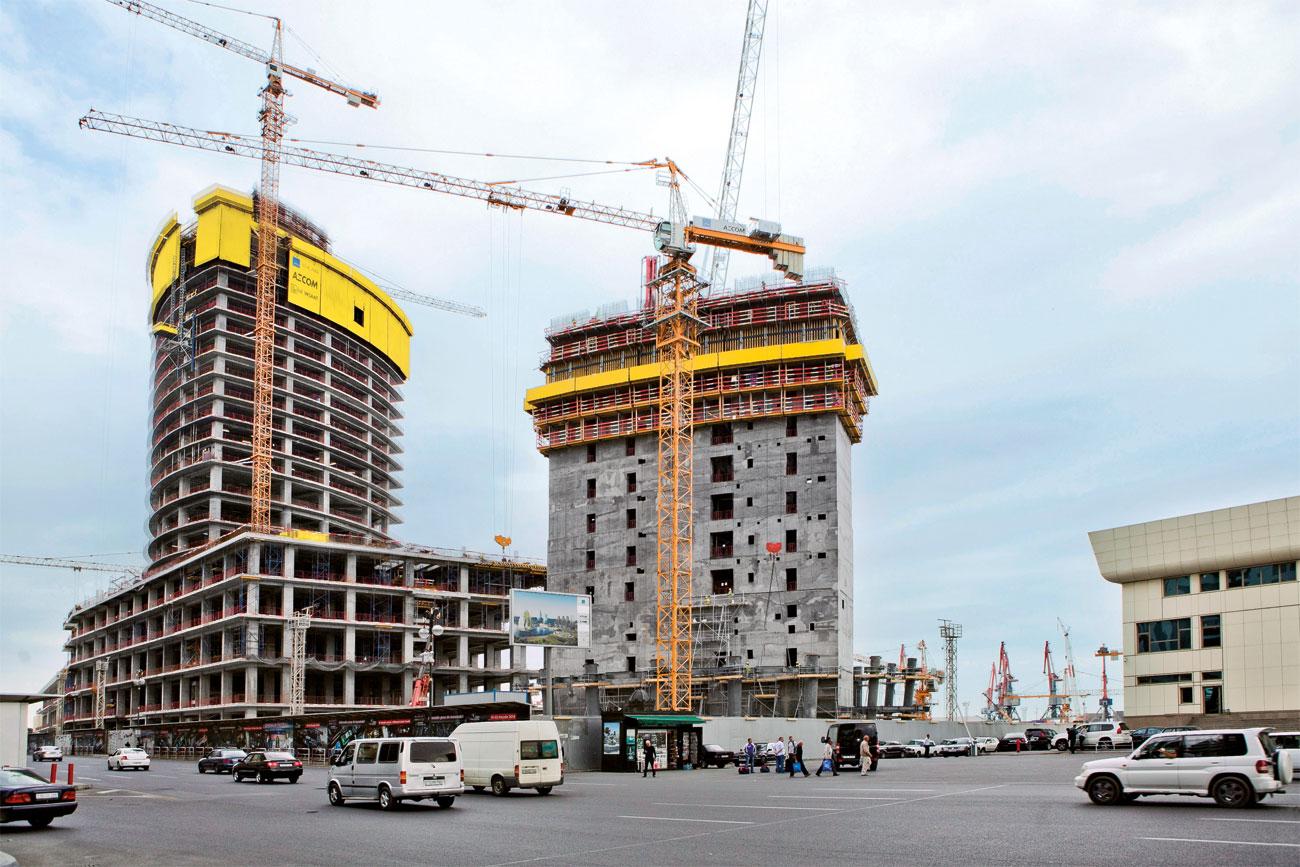 Urban design, Sky, Wheel, Car, Tire, Building, Cloud, Skyscraper, Vehicle, Infrastructure