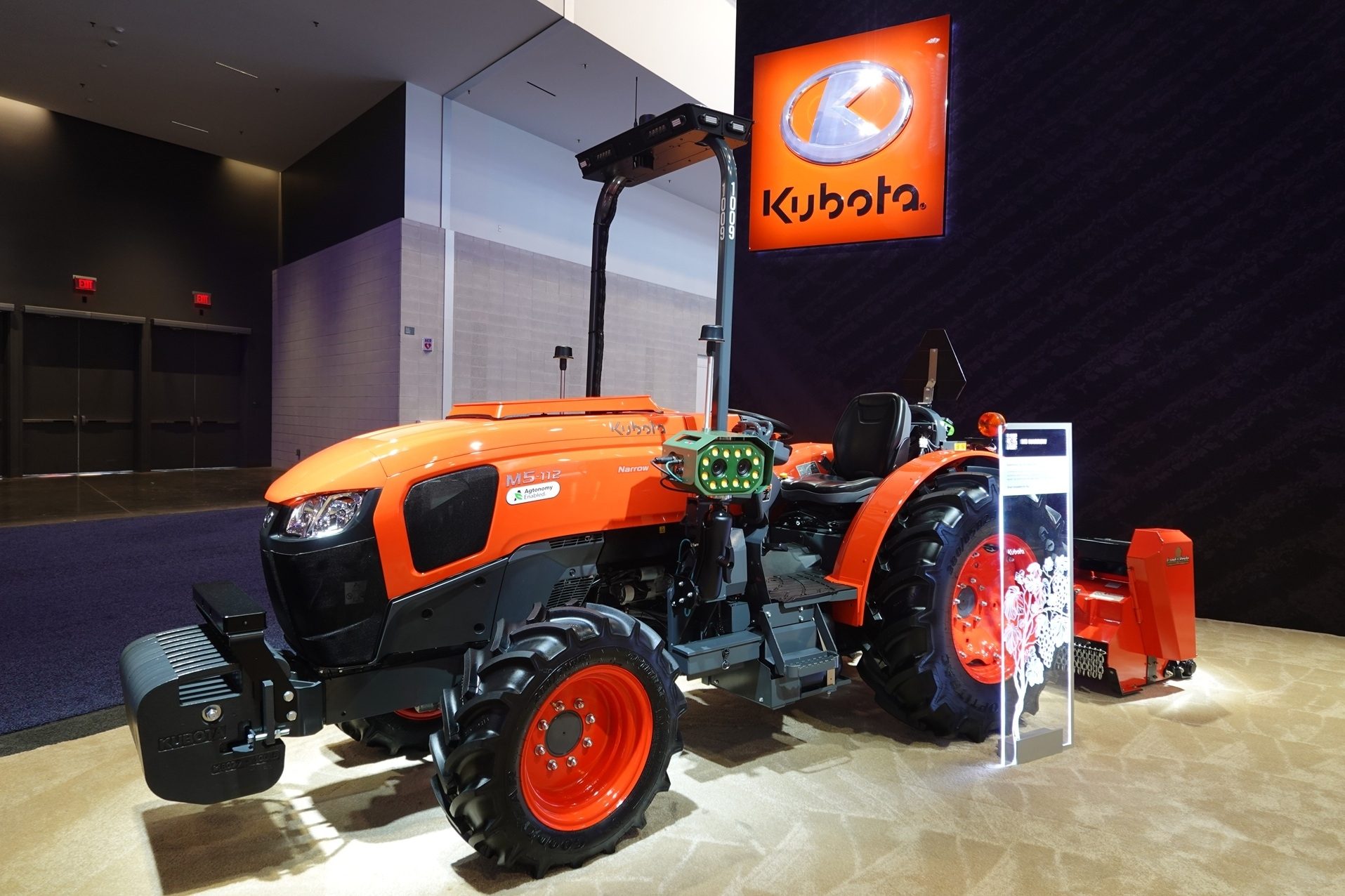 Orange Kubota M5-112 Narrow 'Agronomy Enabled' tractor on display under Kubota logo.