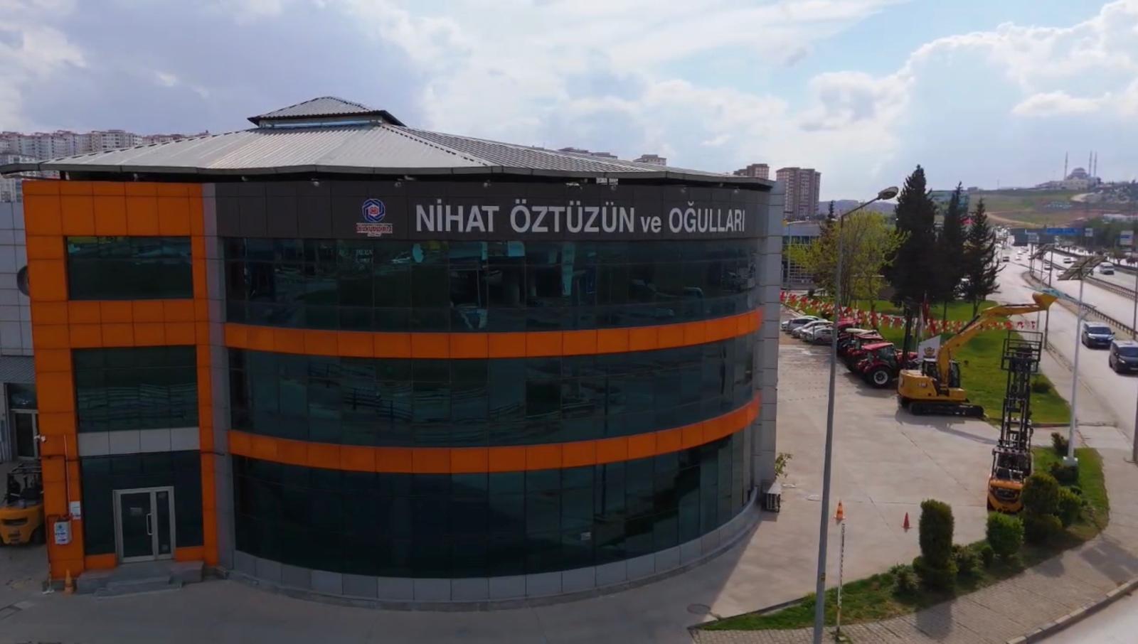 Building "NİHAT ÖZTÜZÜN ve OĞULLARI" with construction vehicles, highway, and a mosque.