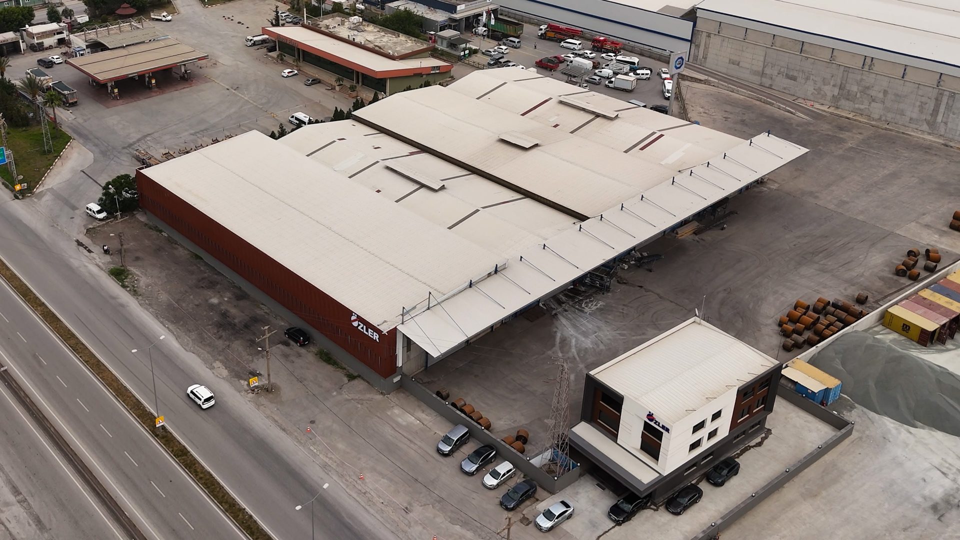 Aerial view of OZLER factory, highway, vehicles, and materials.
