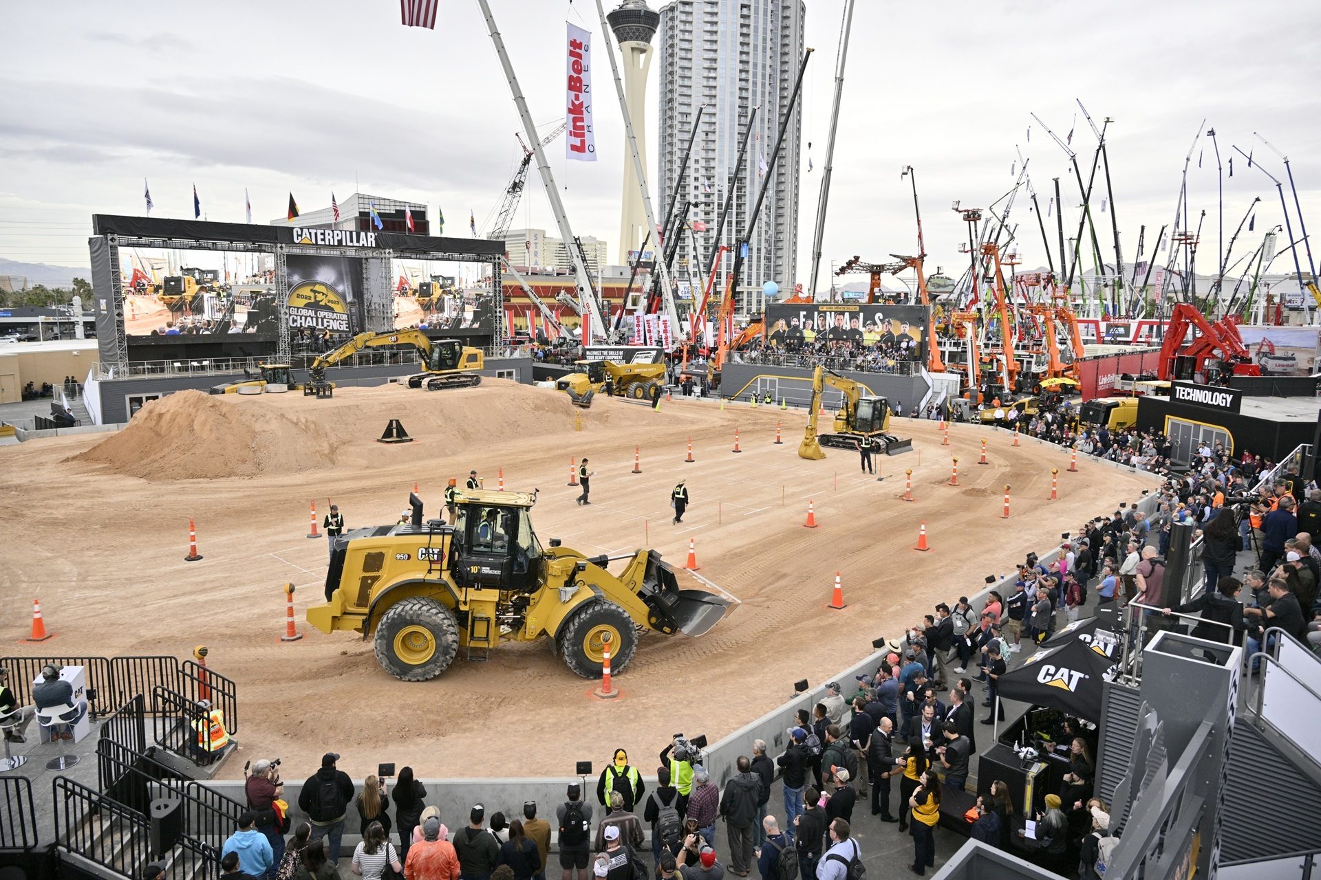 Caterpillar Global Operator Challenge finals with heavy machinery operating in a dirt arena.