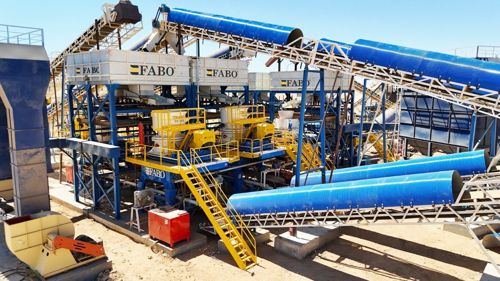 Industrial plant with blue conveyors, yellow machinery, and "FABO" branding.