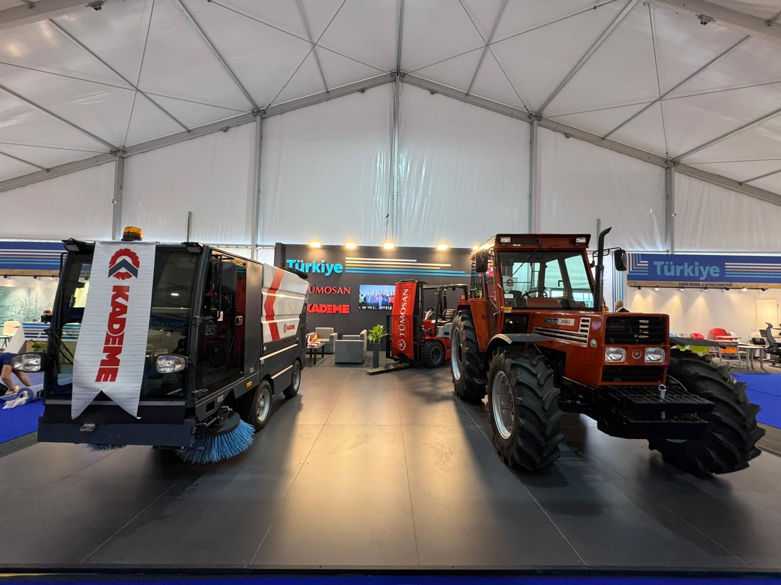A street sweeper and a tractor are on display at an exhibition tent with Türkiye branding.