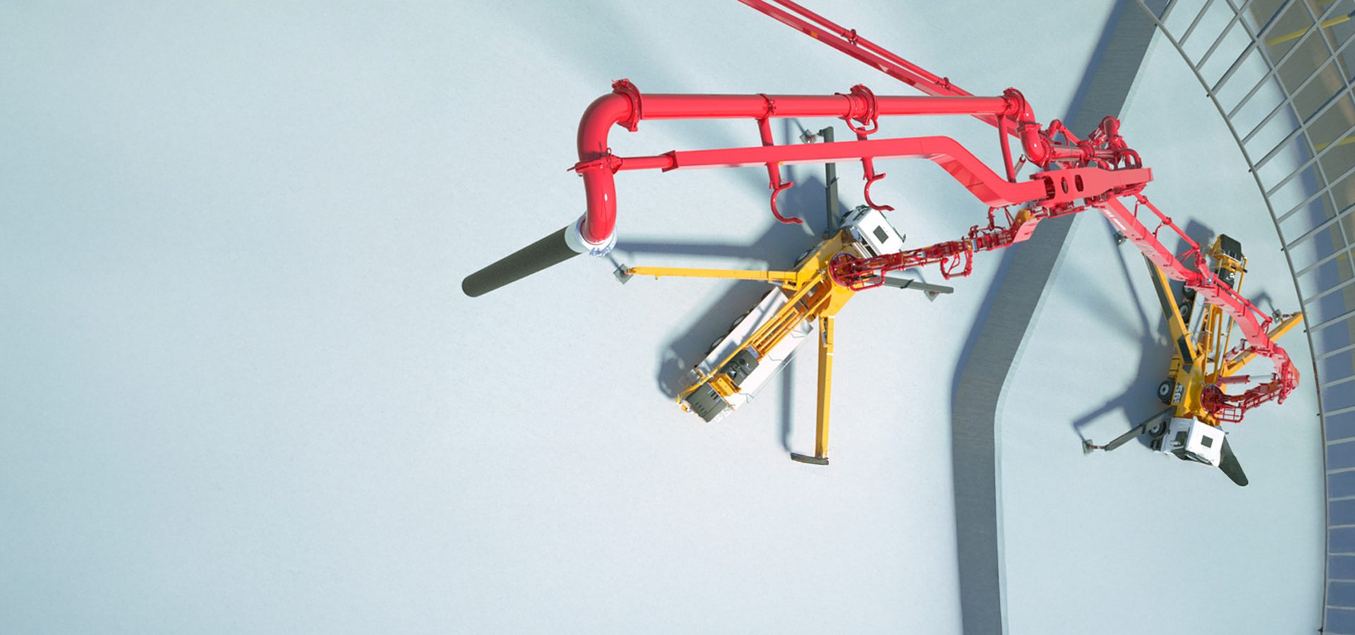 Overhead view of red concrete pump booms and yellow pump trucks on a light blue floor.