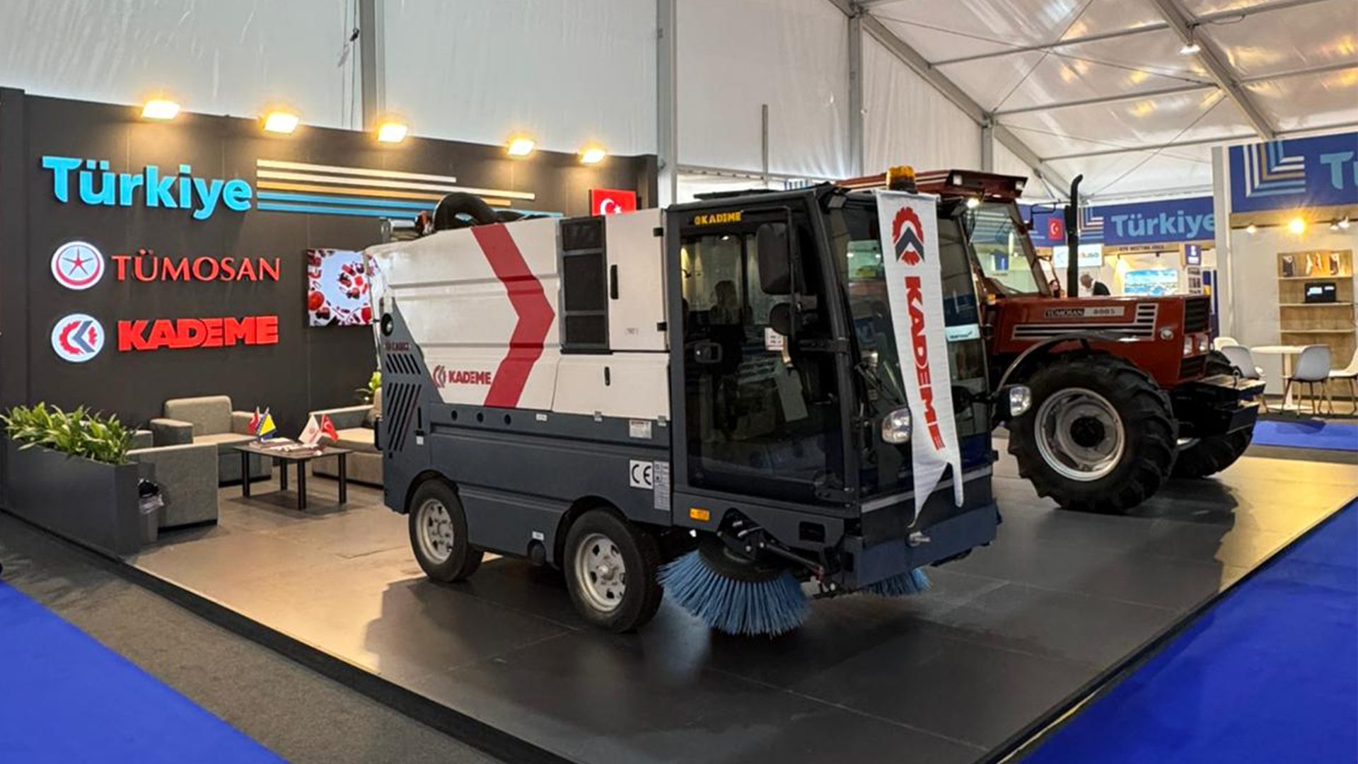 A KADEME street sweeper and a TÜMOSAN tractor displayed at a "Türkiye" exhibition booth.