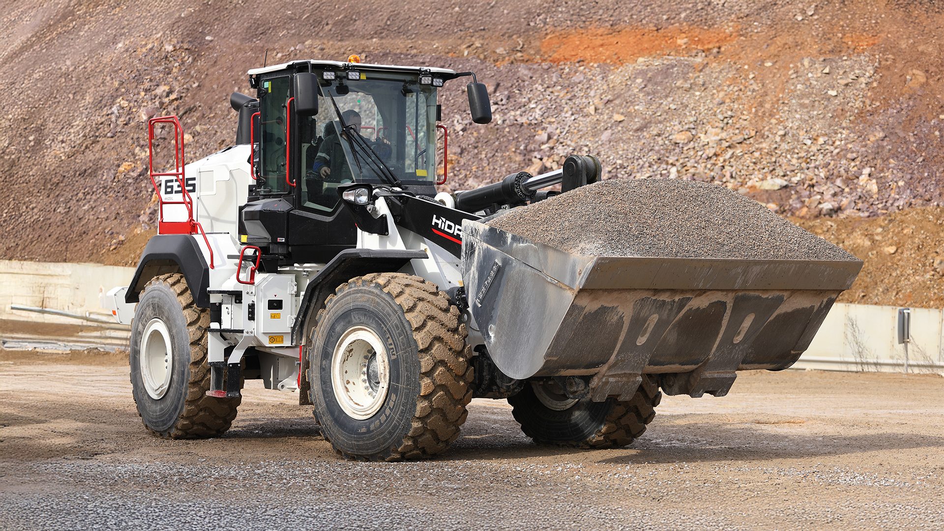 HİDROMEK HMK 635 wheel loader with a full gravel bucket on a construction site.