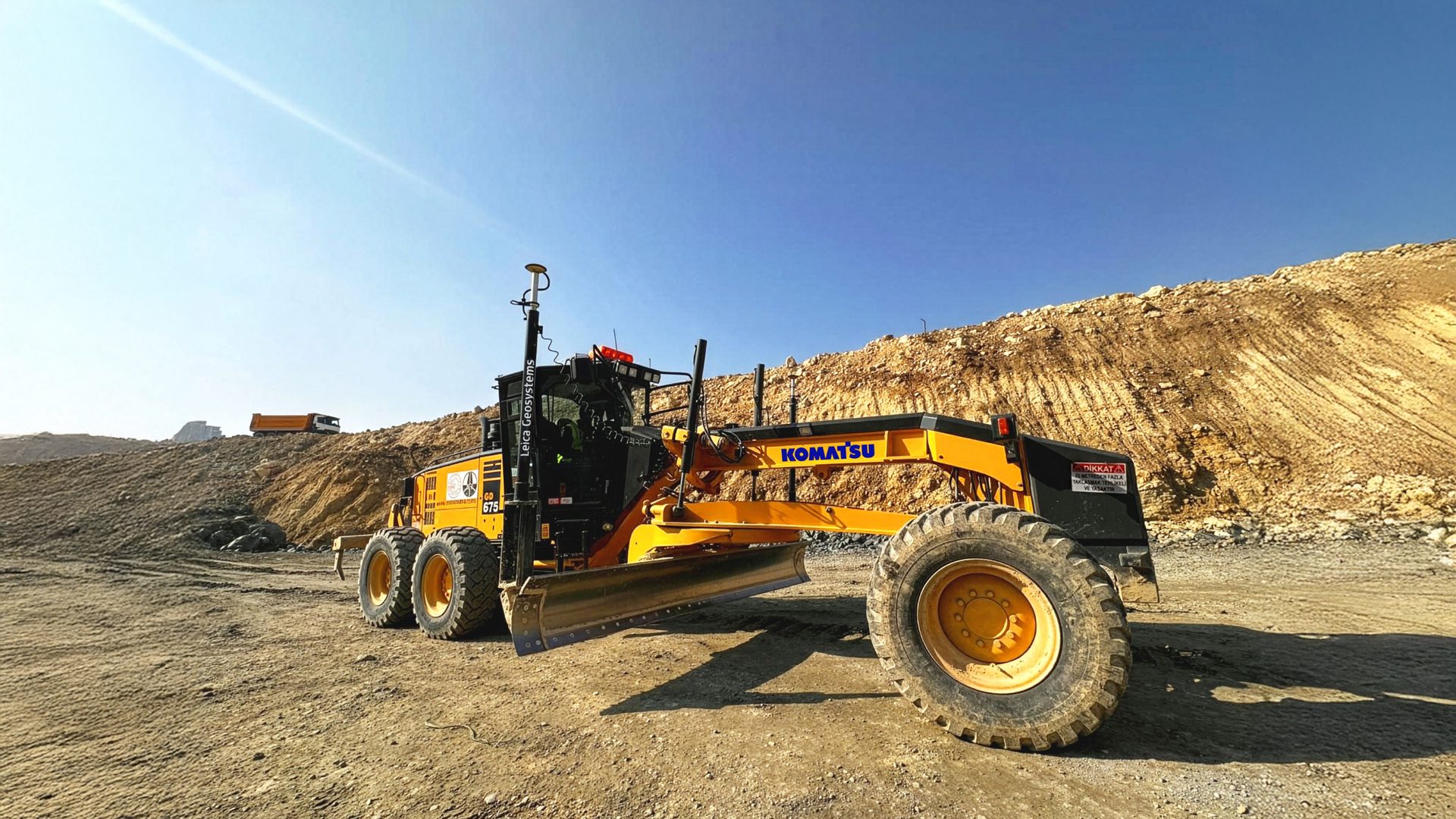 Komatsu grader with Leica GPS on a construction site.