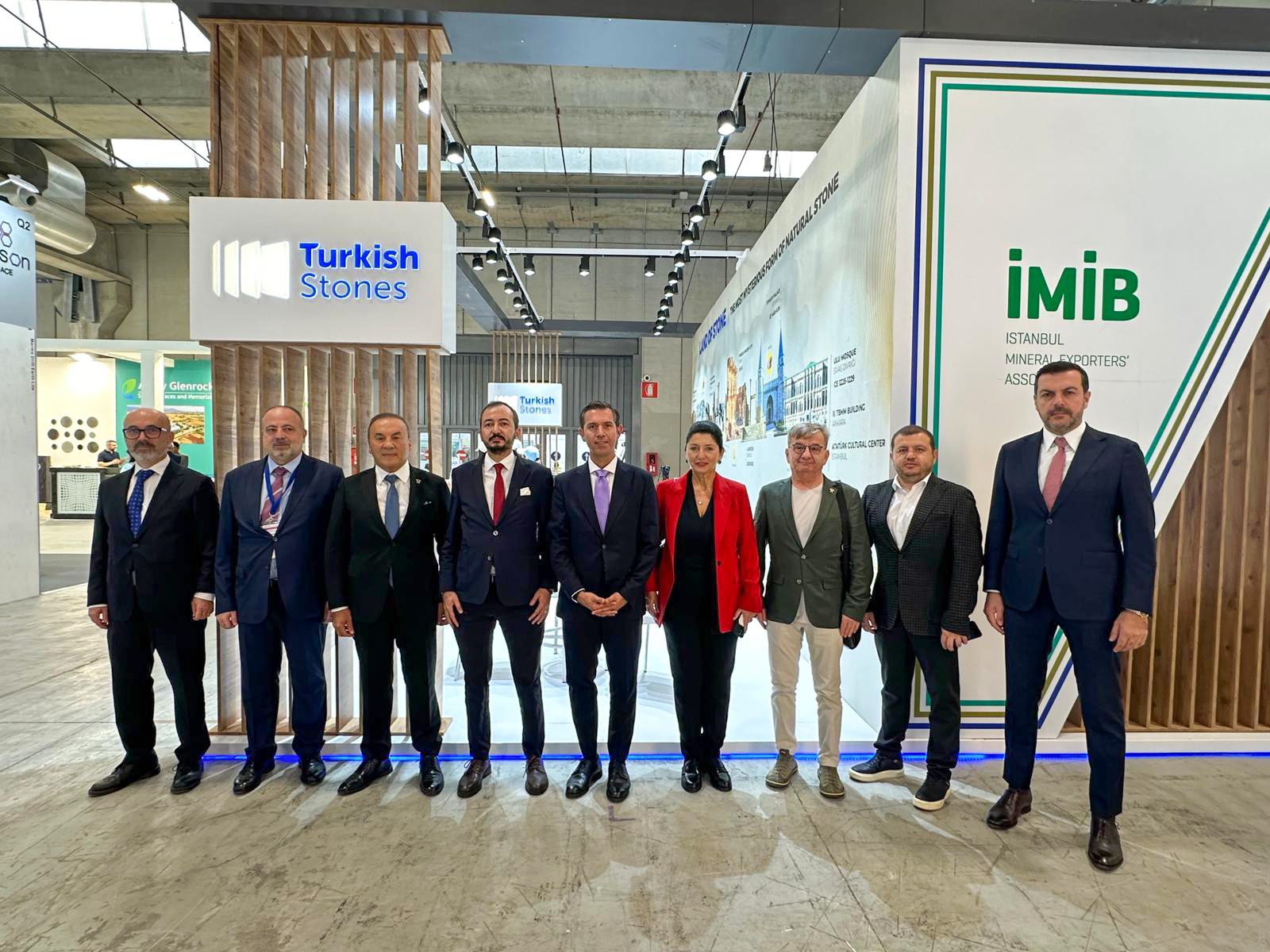 Nine professionals pose at an exhibition booth for 'Turkish Stones' and 'İMİB' (Istanbul Mineral Exporters' Association).