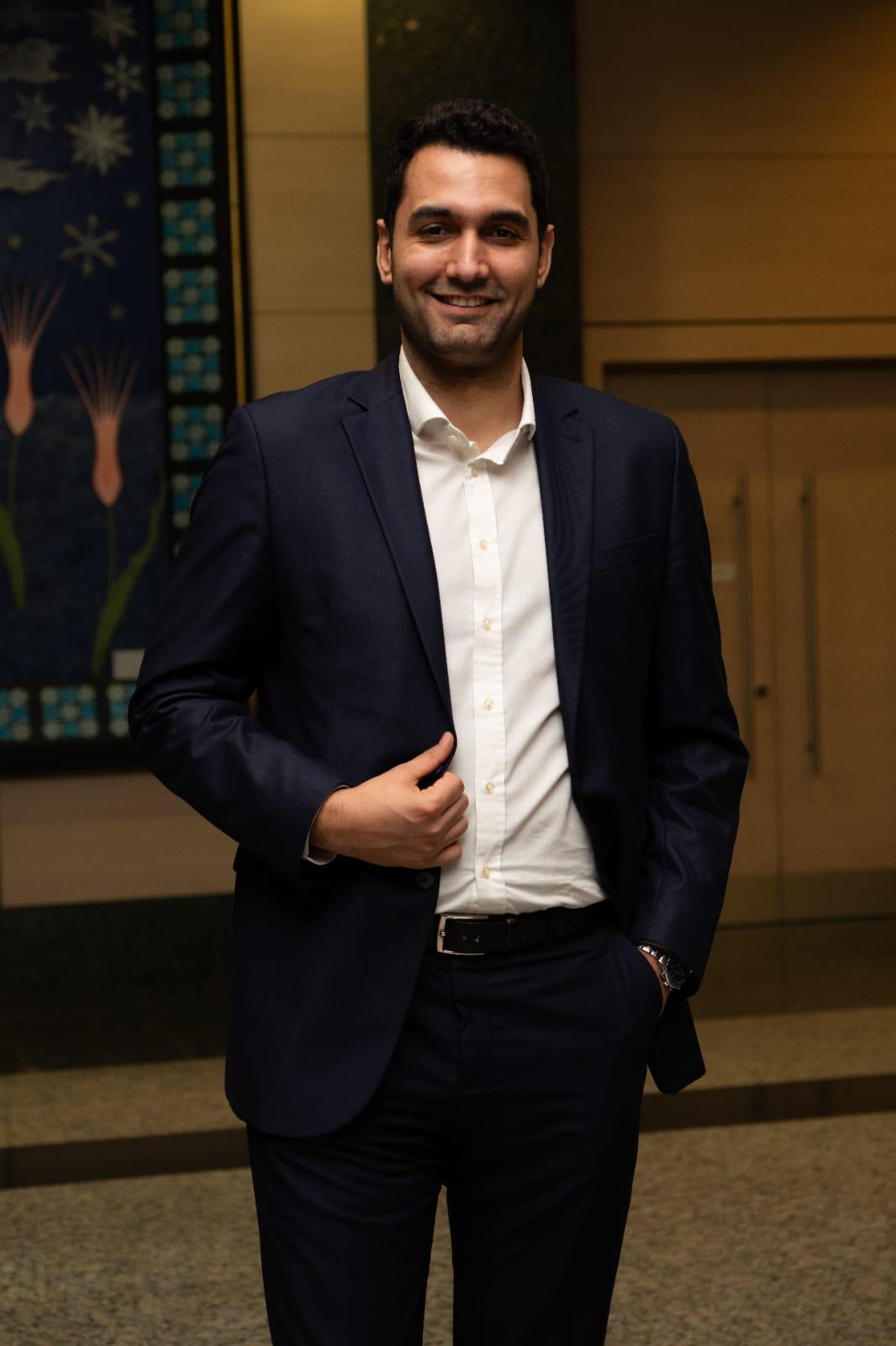 Formal wear, Facial expression, Dress shirt, Sleeve, Collar, Smile, Shoulder, Standing, Blazer, Happiness