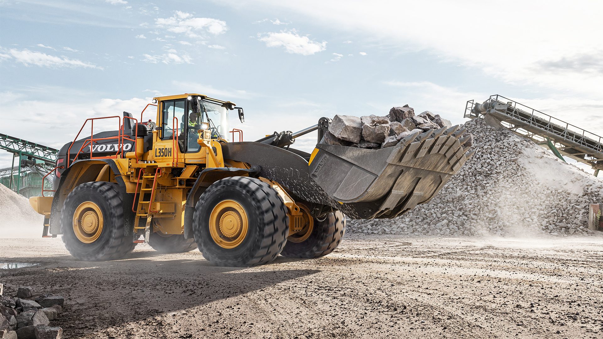 Yellow Volvo L350H loader moving rocks in a quarry.
