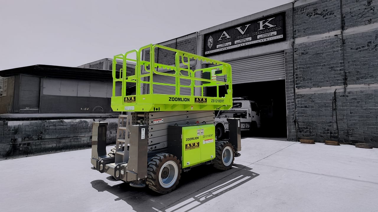Green Zoomlion scissor lift outside an AVK building.