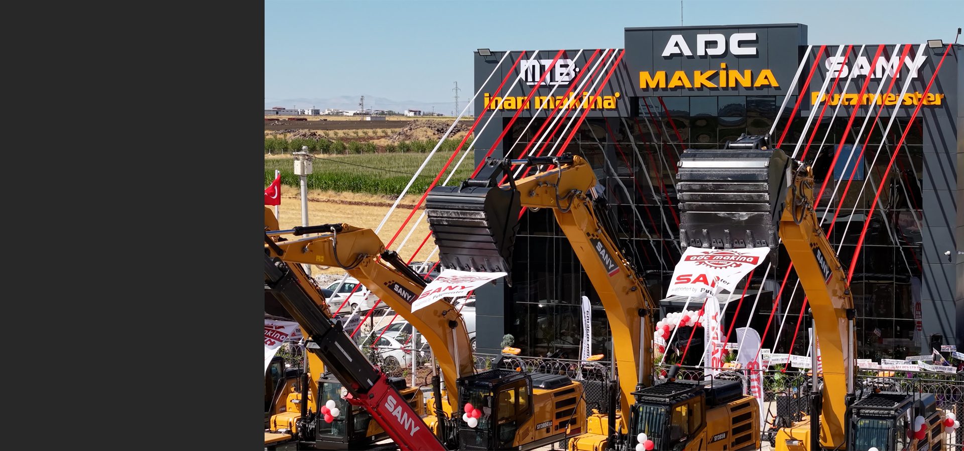SANY excavators in front of an "ADC Makina" building decorated with red and white ribbons.