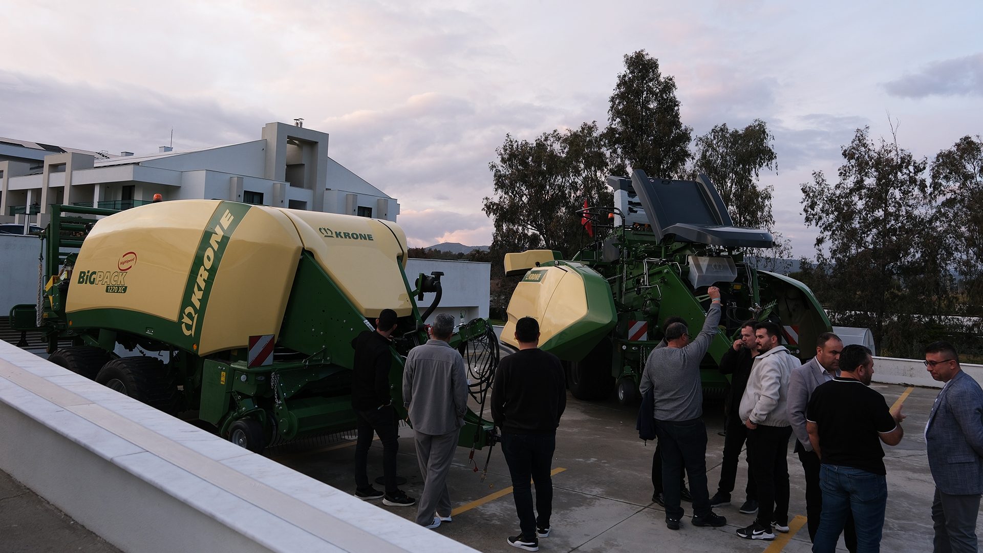 Men inspecting large Krone Big Pack balers.