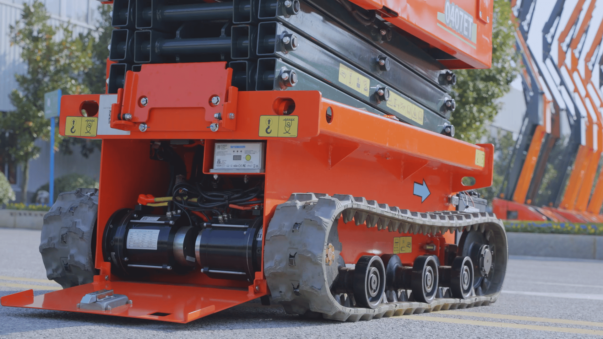 Orange tracked scissor lift base with visible heavy-duty tracks and internal motors.
