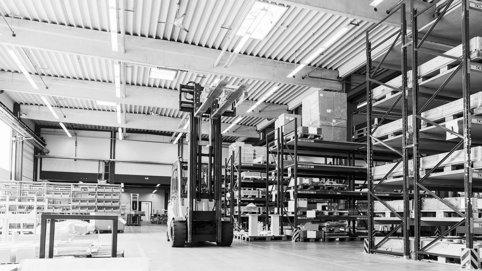 Forklift in a warehouse with shelves full of goods.