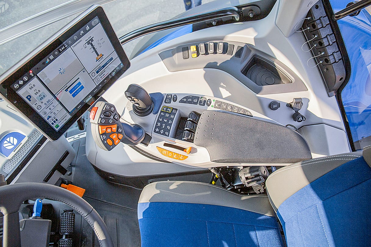 Detailed view of a modern tractor cab interior, highlighting the large digital display, joystick, and control panels.