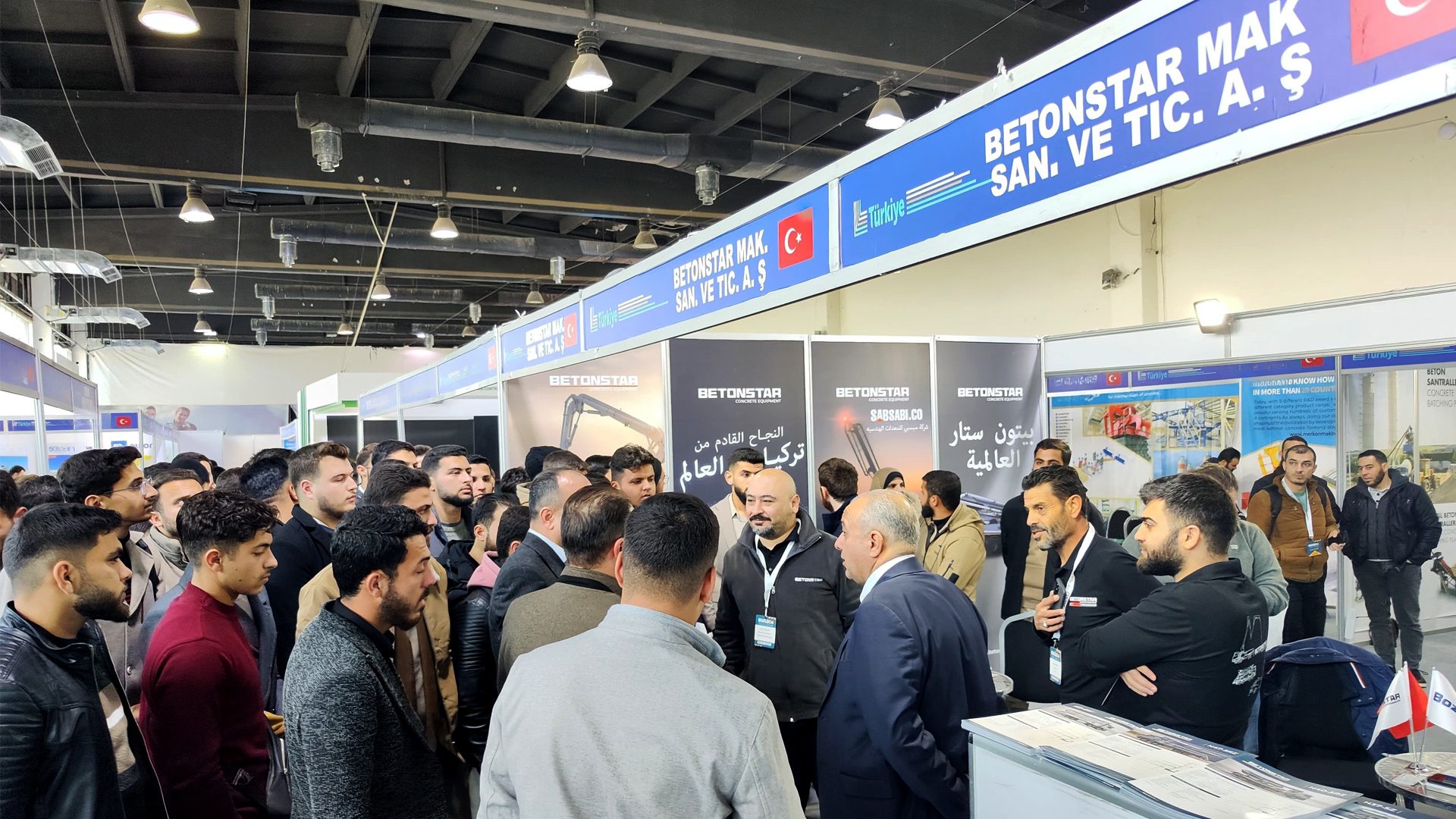 Crowded exhibition hall with attendees gathered at the BETONSTAR booth.