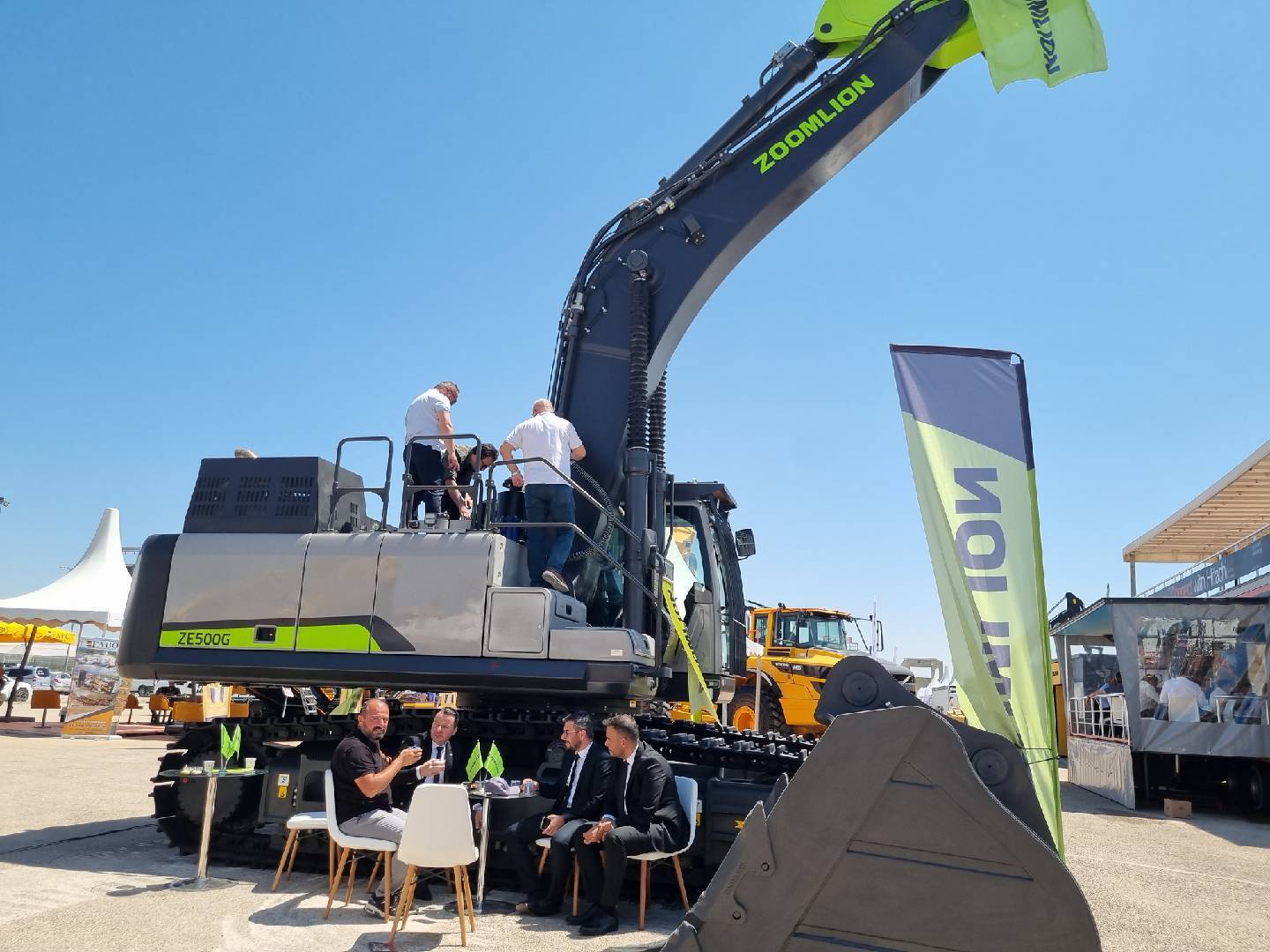 Large Zoomlion ZE500G excavator outdoors with people around it at a trade show.