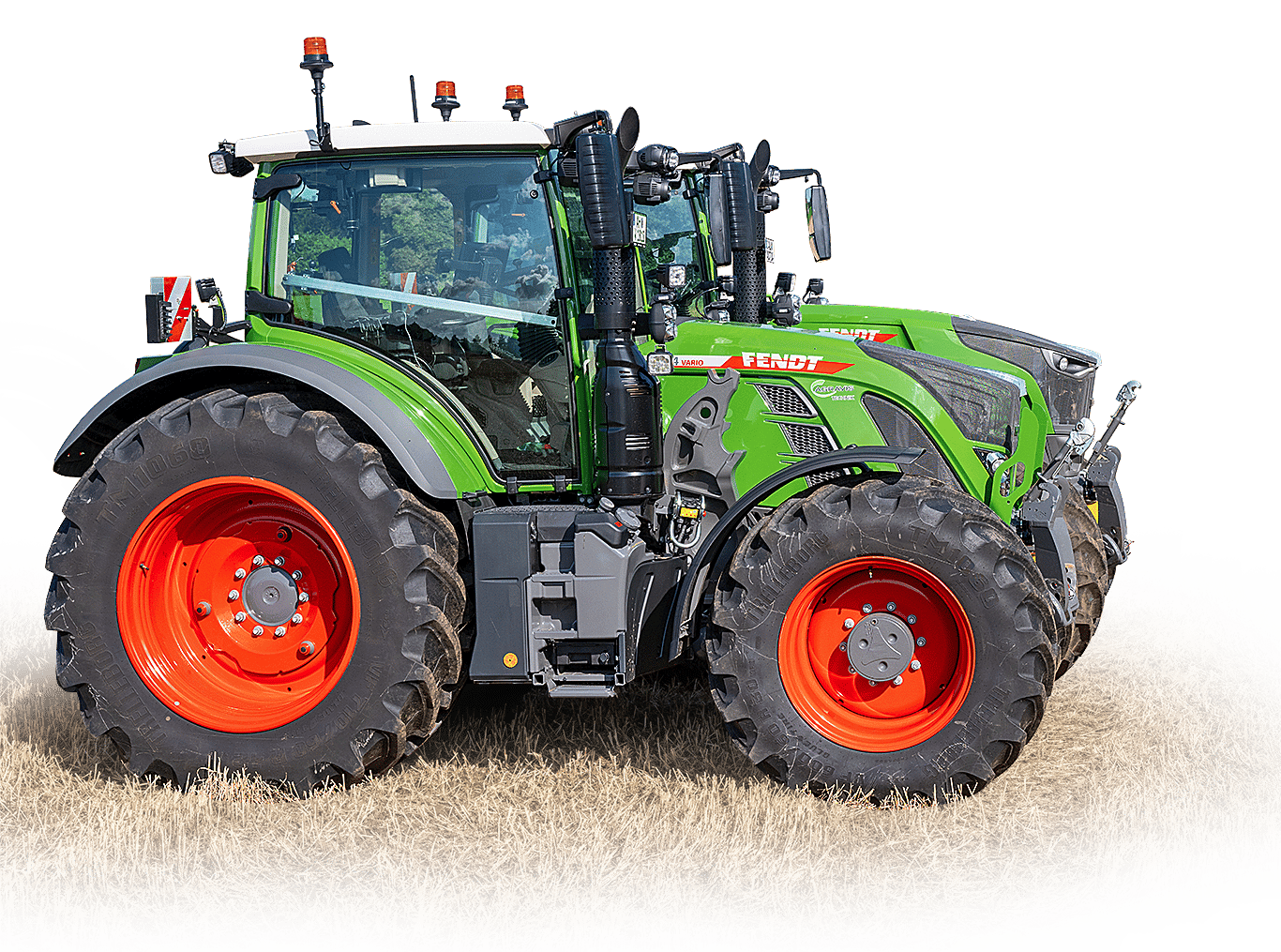 Green Fendt tractor with orange wheels on a dry field.