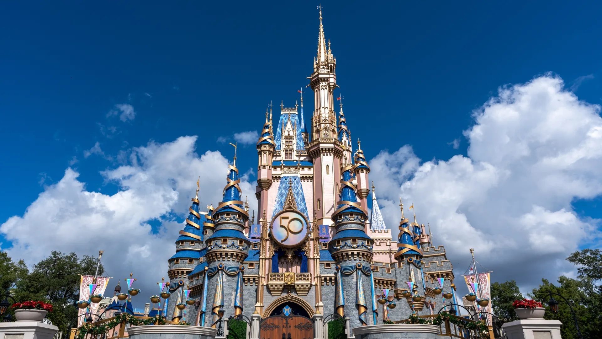 Cinderella Castle at Disney World, with 50th anniversary decor under a blue sky.