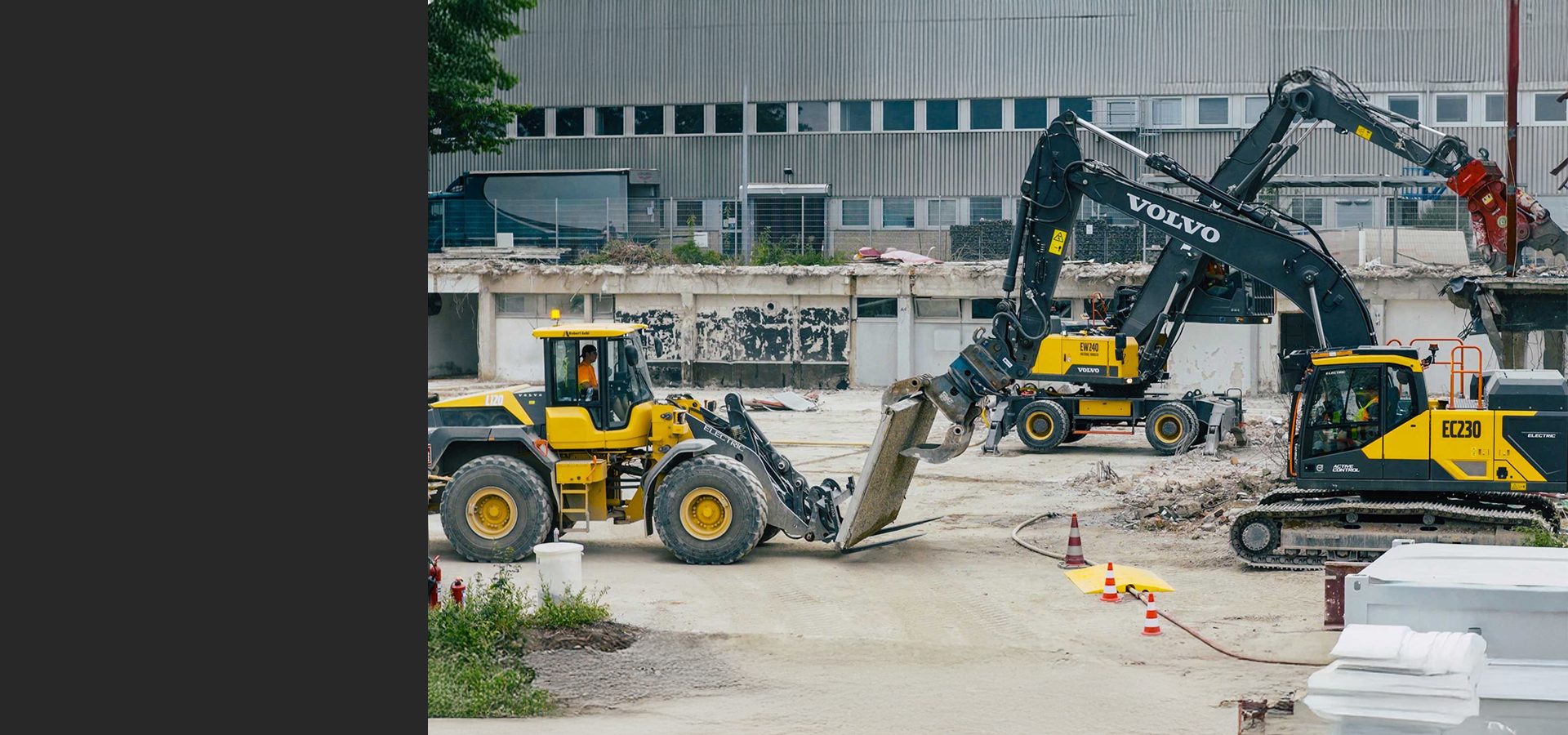 Three yellow Volvo demolition machines, including excavators and a front loader, at a construction site.