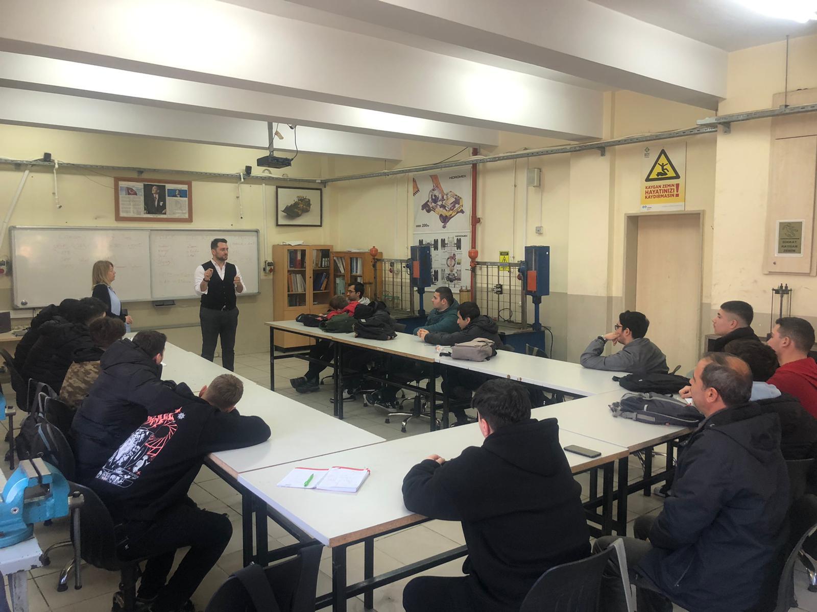 Man presents to students in a workshop/classroom setting.