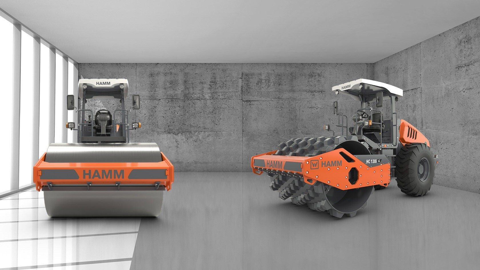 Two Hamm road rollers, smooth drum and padfoot types, in a concrete room.
