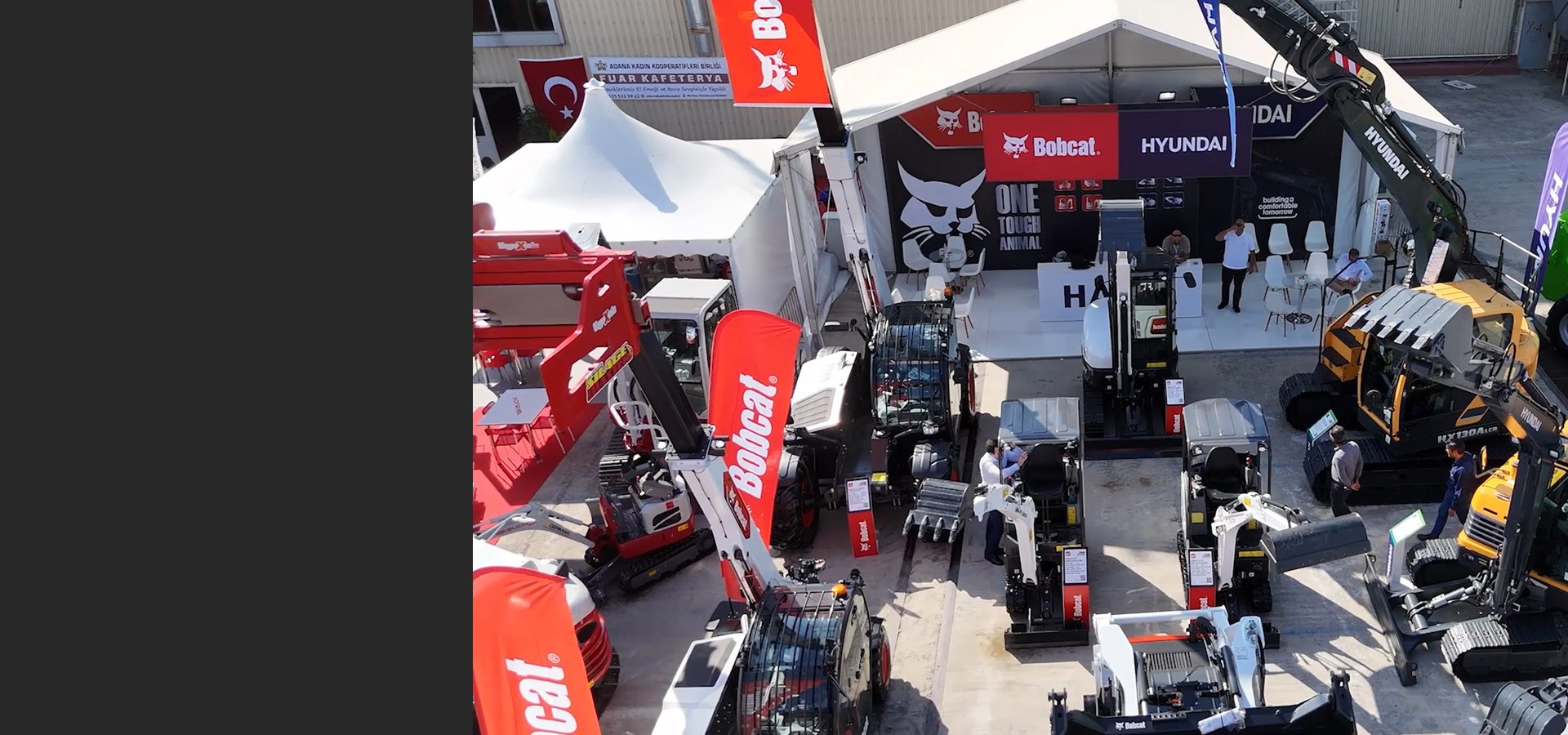 Aerial view of an outdoor construction equipment trade show featuring Bobcat and Hyundai machinery and booths.