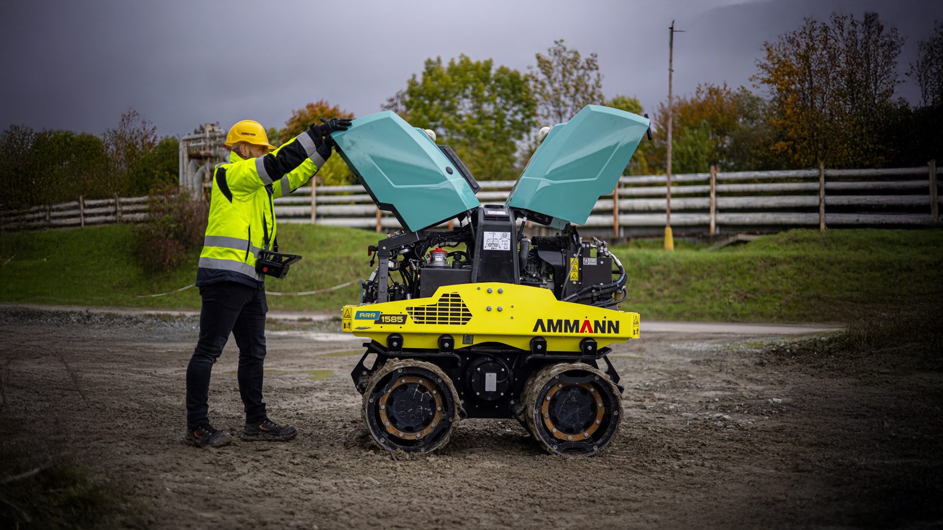 Construction worker opening an Ammann ARR 1585 compacting machine.