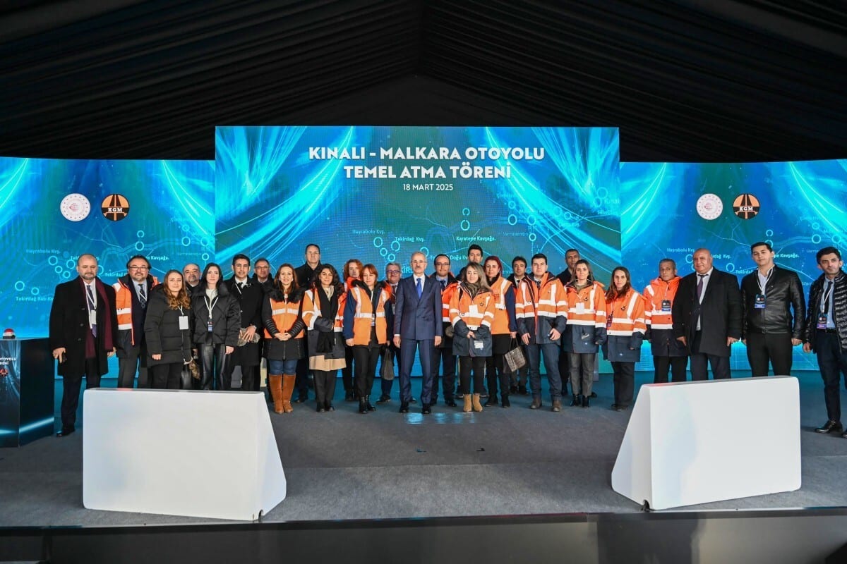 Formal wear, White-collar worker, Suit trousers, Event, Coat, Logo, Stage, Technology, Advertising